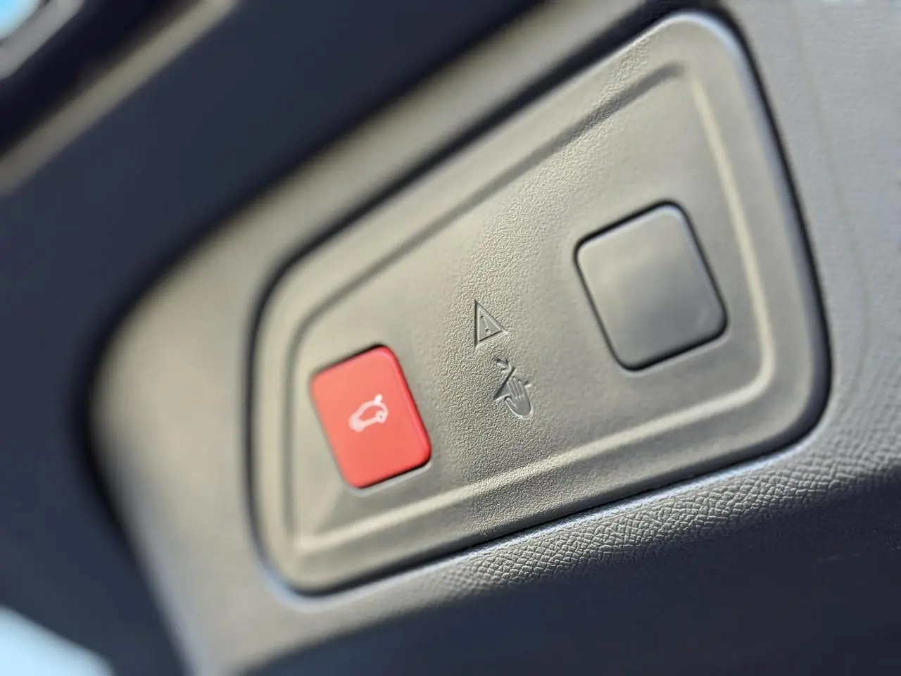 Gros plan sur le bouton rouge d'ouverture du hayon électrique dans l'habitacle du Citroën C5 Aircross Bleu Eclipse.