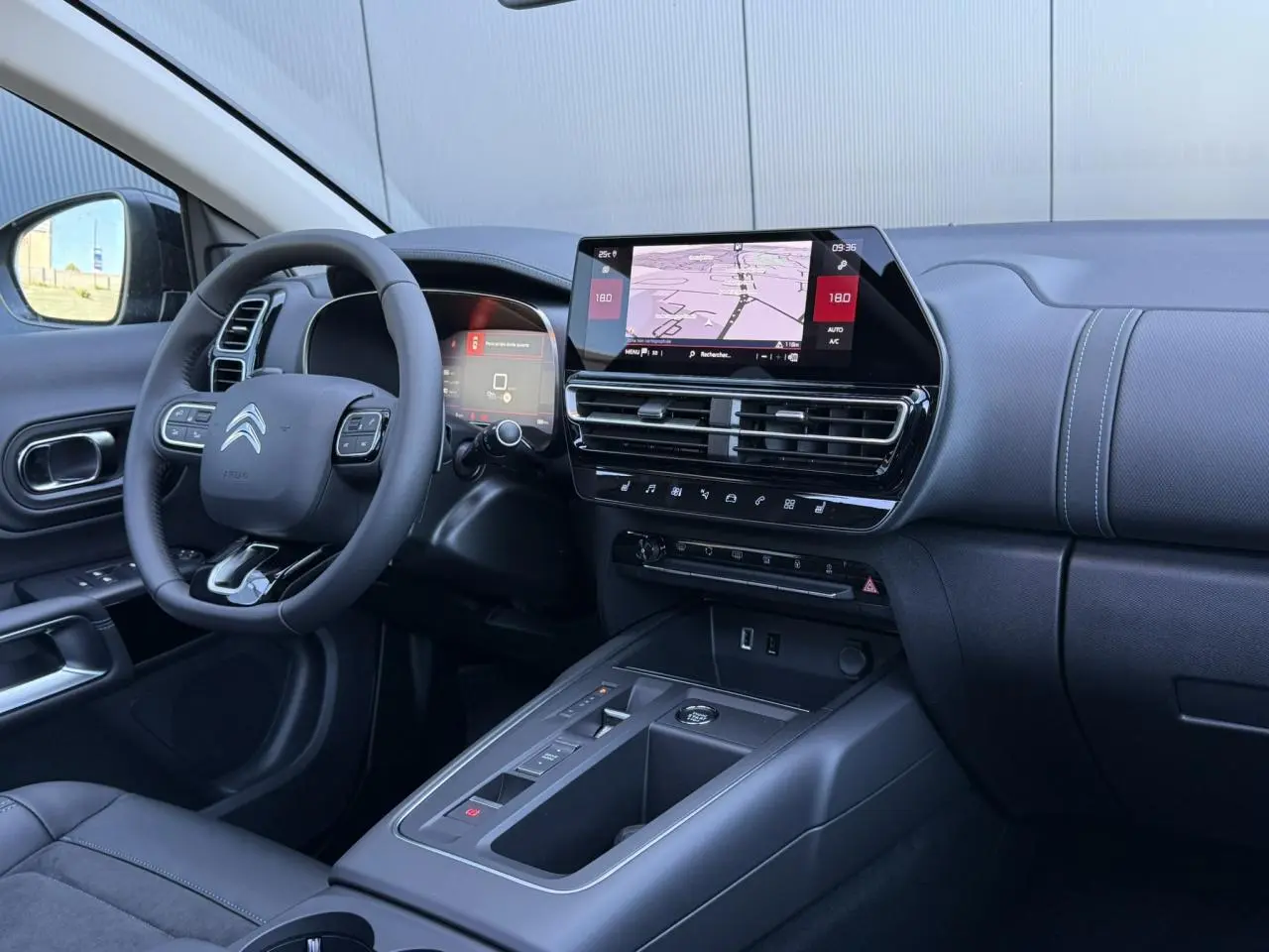 Vue intérieure côté conducteur du tableau de bord noir avec écran tactile et volant Citroën du C5 Aircross 2025.