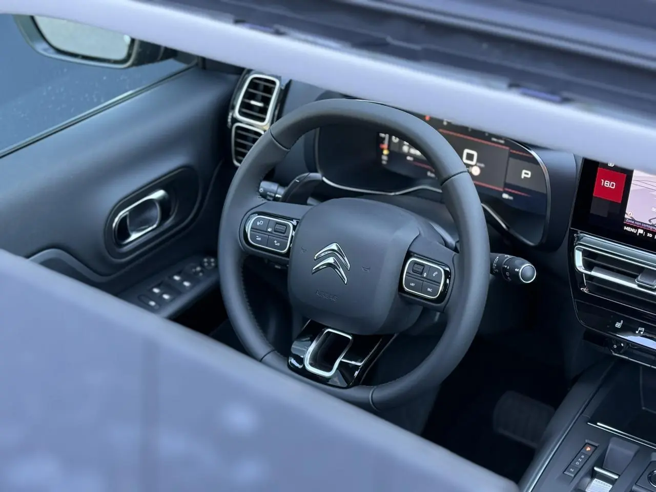 Vue intérieure du volant cuir noir et tableau de bord numérique du Citroën C5 Aircross 2025 avec écran tactile et commandes intégrées.