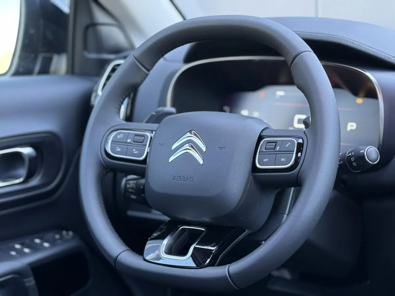 Volant en cuir noir avec commandes intégrées et logo Citroën, vue rapprochée côté conducteur intérieur C5 Aircross.