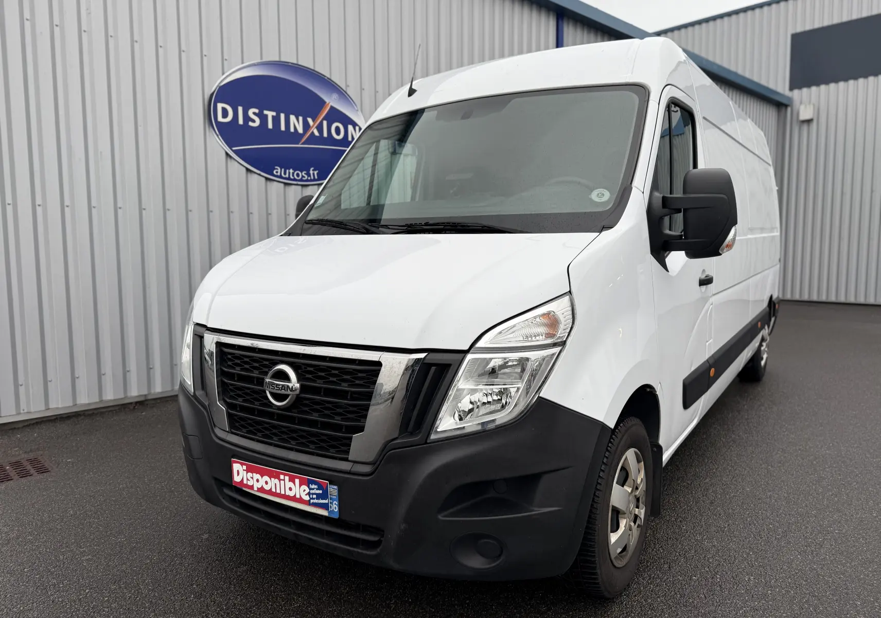 Fourgon Nissan NV400 blanc en vue 3/4 avant droit, avec calandre noire et pare-chocs avant noir mat.