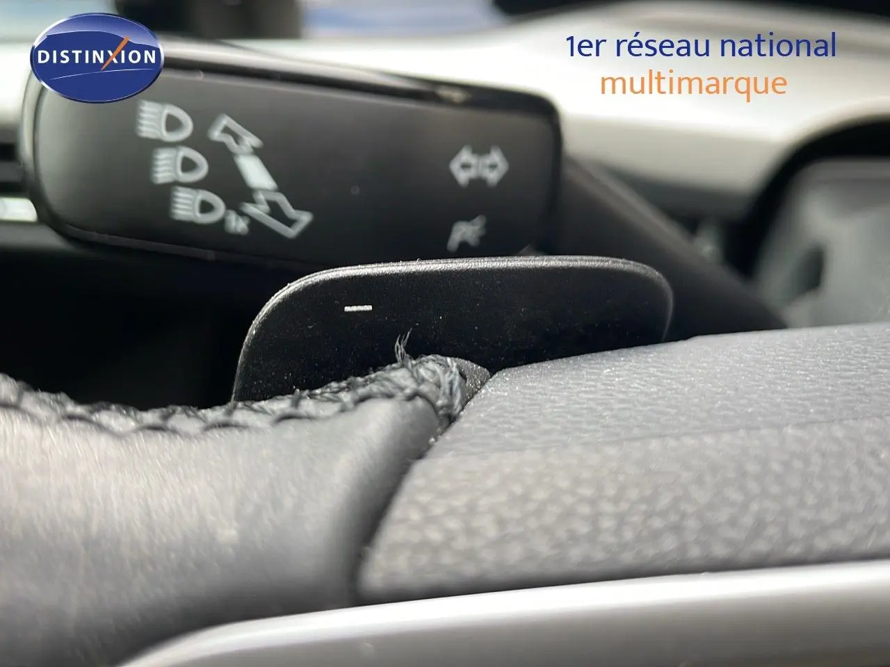 Gros plan sur la palette de changement de vitesses au volant d'une Volkswagen Golf VIII, intérieur noir texturé.