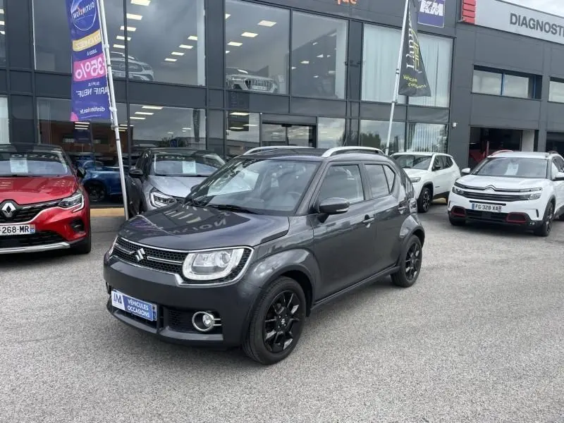 Suzuki Ignis 1.2 Dualjet Hybrid gris foncé métal en vue 3/4 avant, avec jantes noires et toit noir.