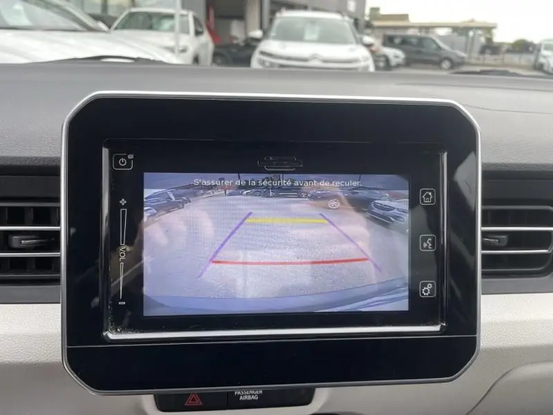 Écran tactile intérieur affichant la caméra de recul d'une Suzuki Ignis gris foncé, vue arrière avec lignes de guidage colorées.