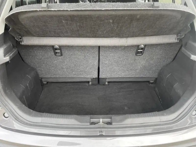 Coffre ouvert vu de l'arrière d'une Suzuki Ignis 2020 gris foncé métal, montrant l'espace de chargement et la tablette cache-bagages.