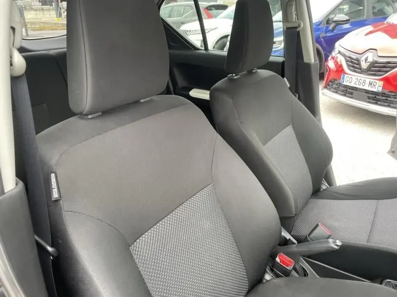 Vue intérieure rapprochée des sièges avant noirs du Suzuki Ignis 2020, avec ceinture de sécurité et frein à main visible.