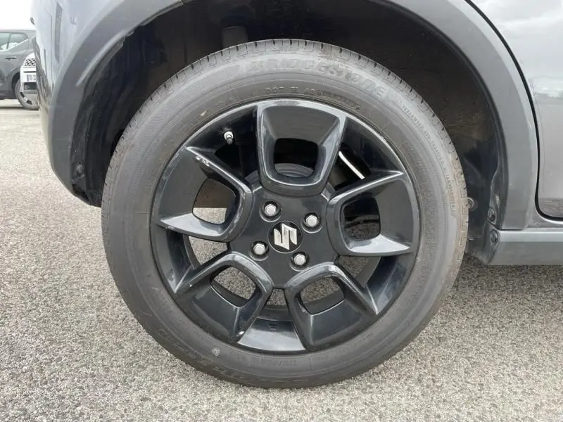 Gros plan sur la roue avant gauche du Suzuki Ignis gris foncé 2020 avec jante noire au design moderne.