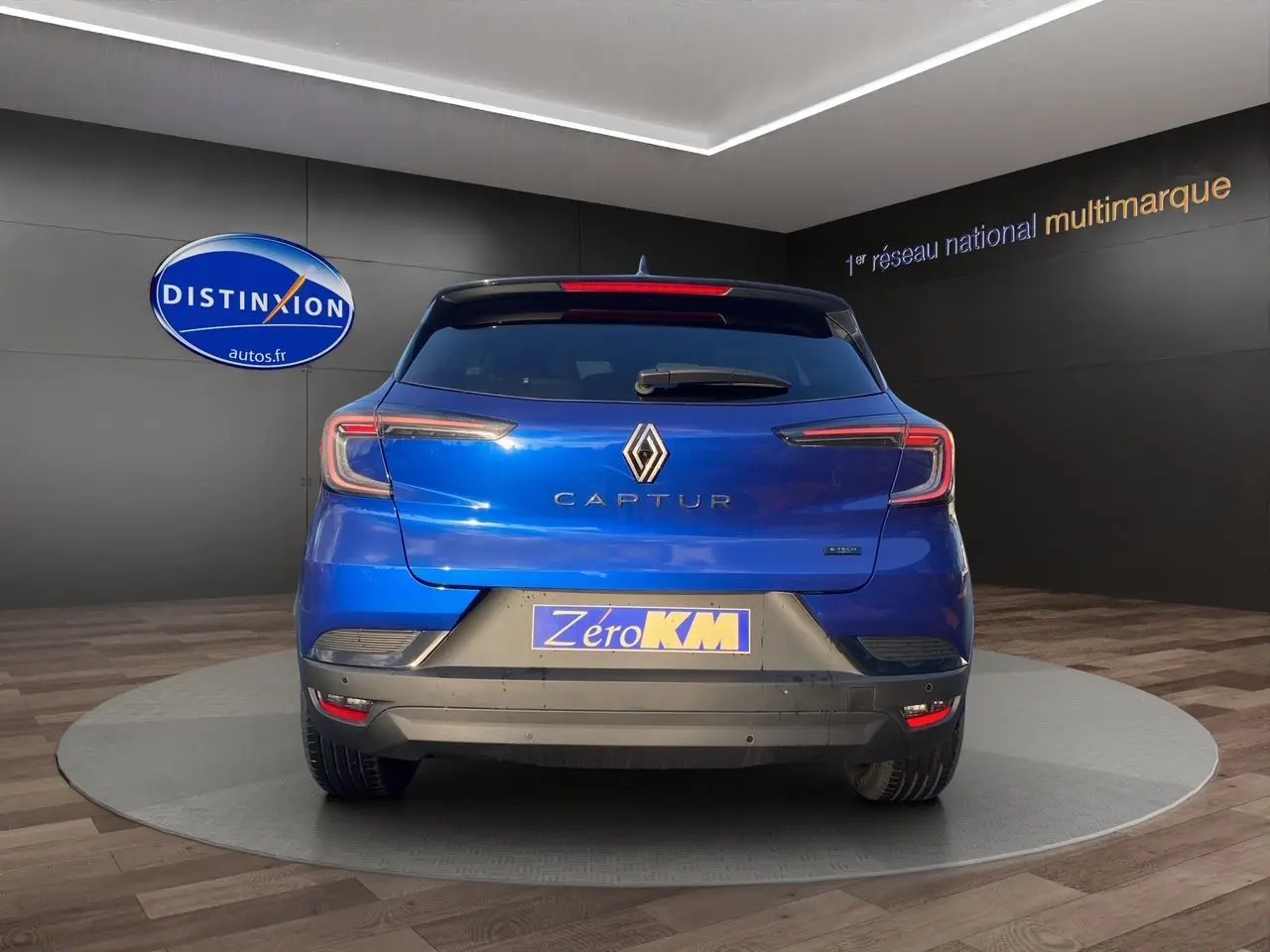 Vue arrière d'un Renault Captur 2025 bleu Iron avec toit noir, mettant en valeur ses feux LED et son logo central.