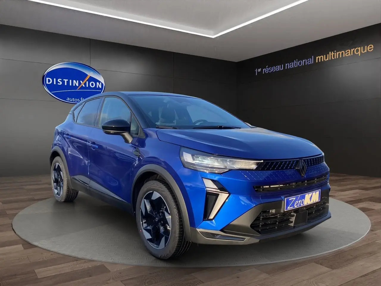 Renault Captur 2025 bleu Iron avec toit noir, vue 3/4 avant droit mettant en valeur ses optiques fines et jantes stylées.