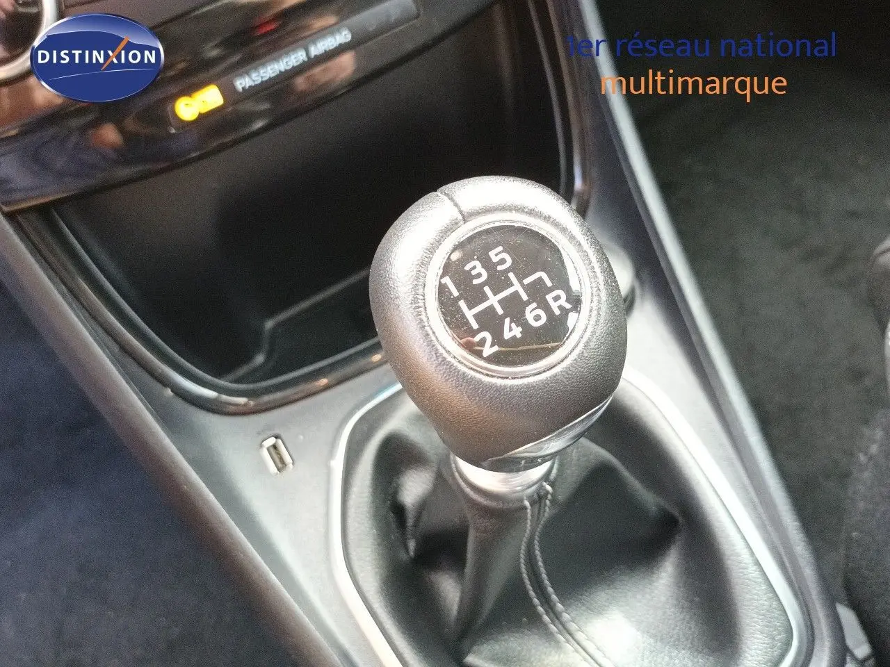 Gros plan sur le levier de vitesses manuel noir de la Ford Puma gris foncé, avec indication des six rapports et marche arrière.
