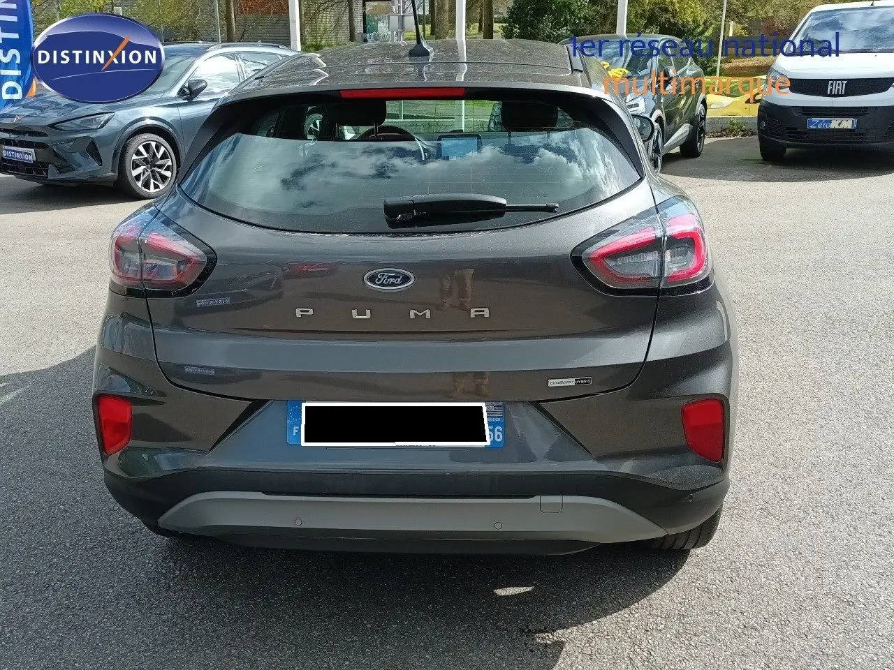 Vue arrière d'une Ford Puma gris foncé métal 2023 avec feux LED et logo bien visibles sur un parking extérieur.