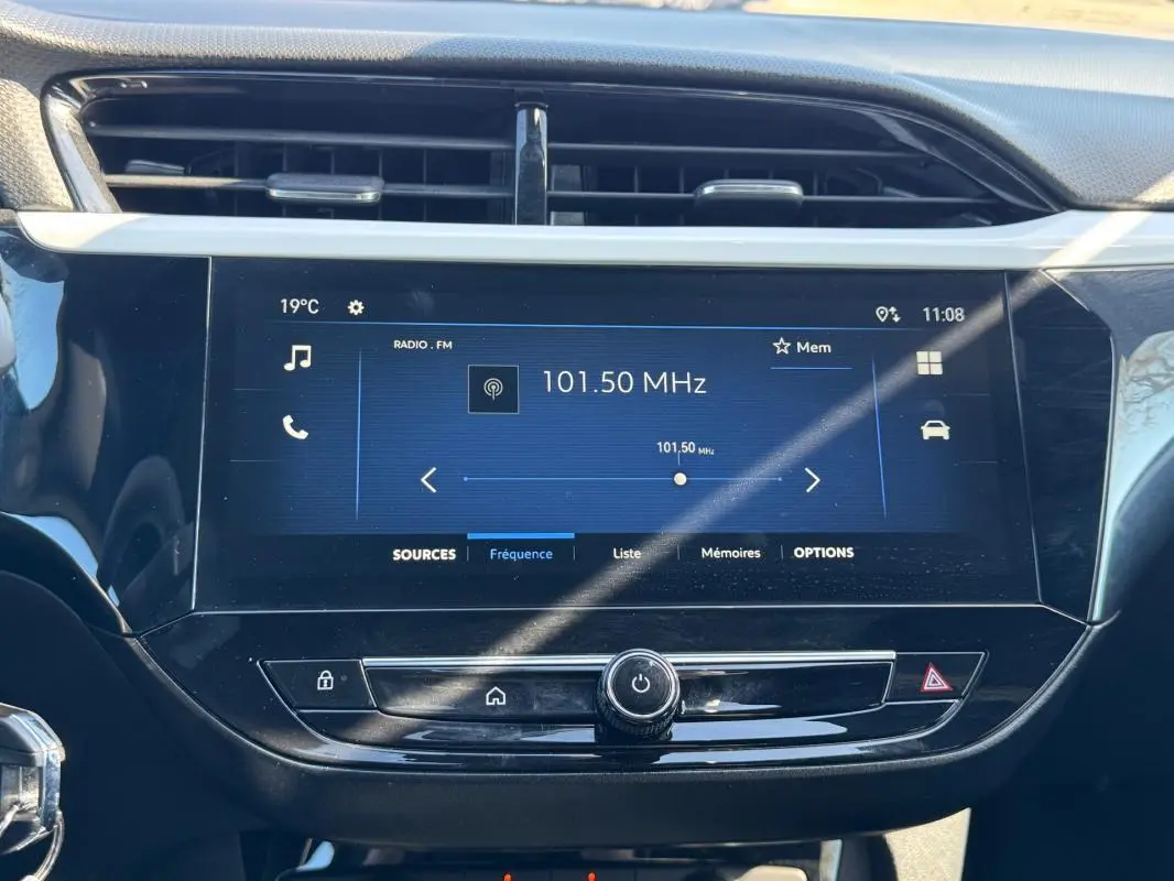 Écran tactile central de l’Opel Corsa rouge 2025 affichant la radio FM à 101,50 MHz avec commandes sous l’écran.