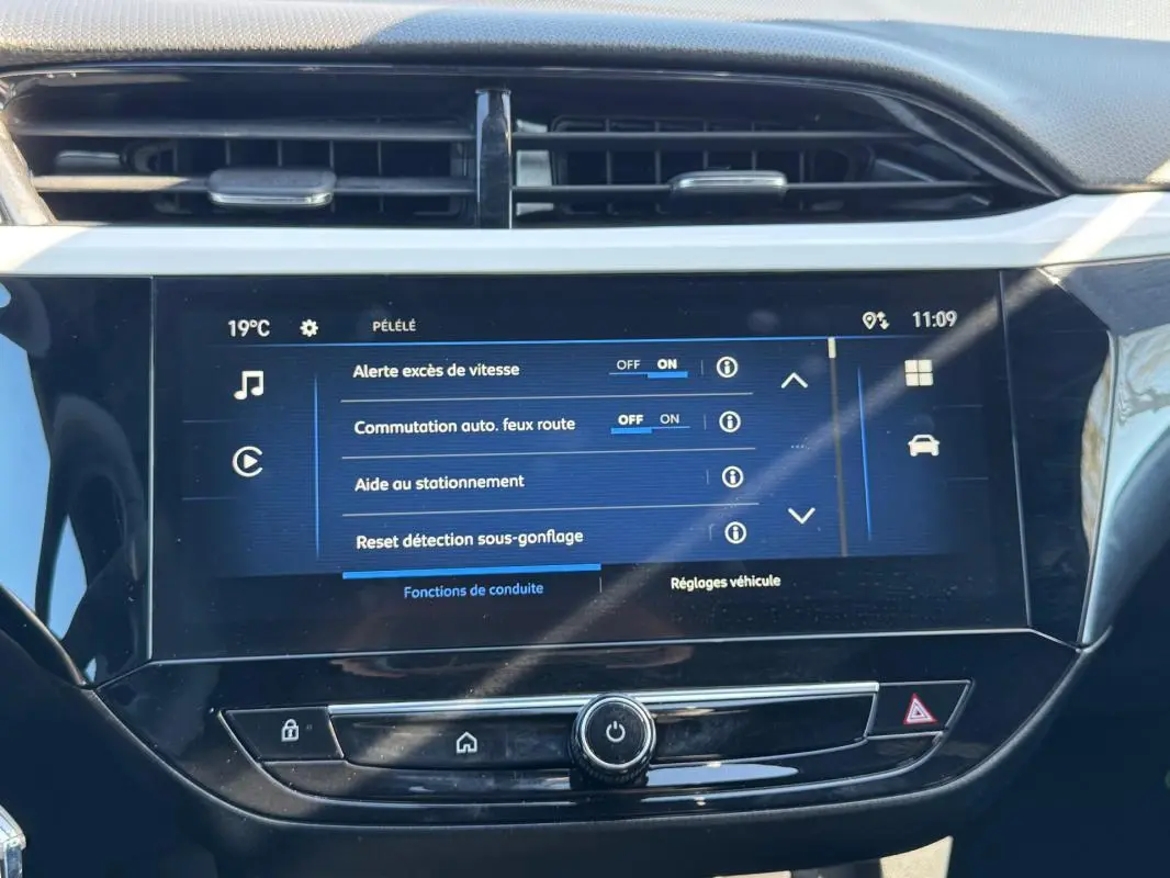 Écran tactile central de l’Opel Corsa rouge 2025 affichant les réglages d’aide à la conduite et d’éclairage.