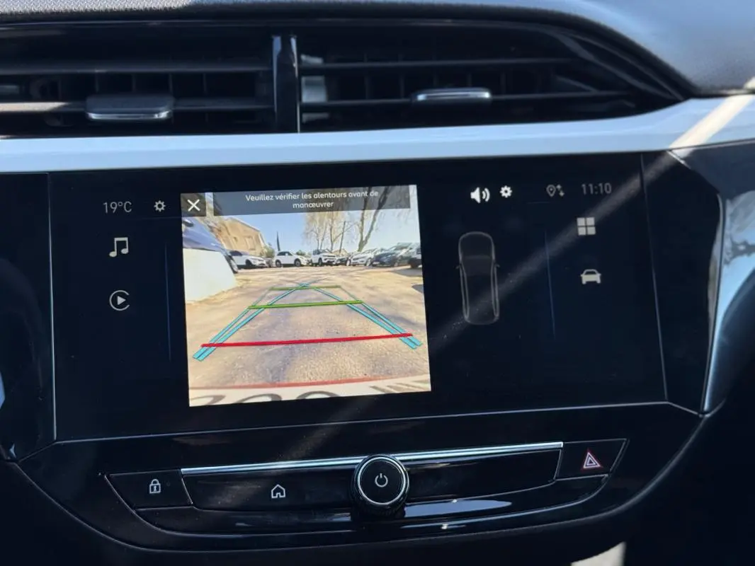 Écran central de l’Opel Corsa rouge 2025 montrant la caméra de recul avec les lignes de guidage colorées.