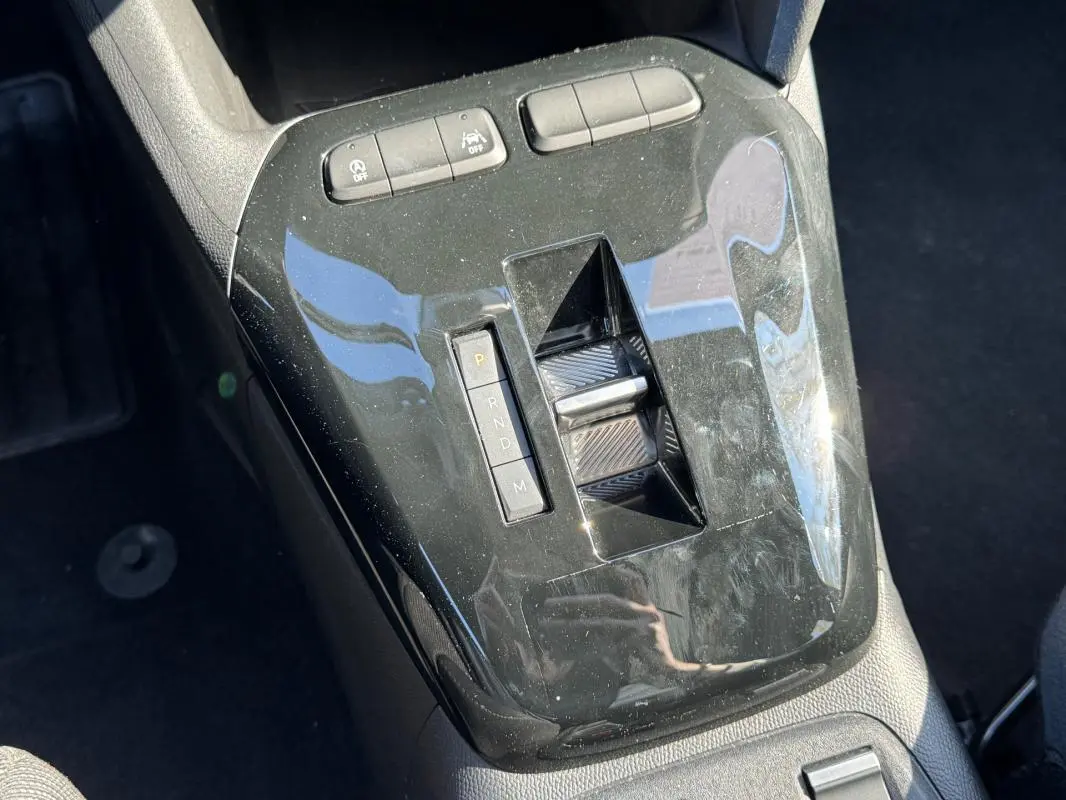 Vue rapprochée de la console centrale noire brillante de l’Opel Corsa 2025 avec sélecteur de boîte automatique et boutons de contrôle.