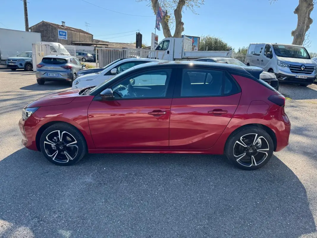 Opel Corsa rouge vue de profil côté gauche, avec jantes alliage noires et toit noir contrasté.