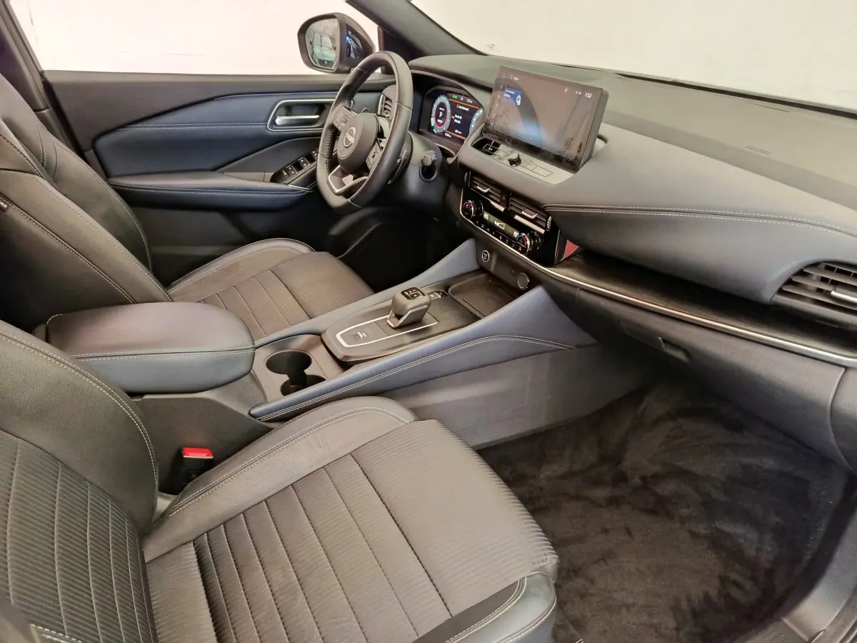 Intérieur noir du Nissan Qashqai 1.3 MHEV 158ch Tekna, vue côté conducteur avec tableau de bord digital et écran tactile.