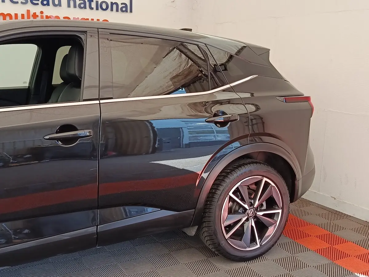 Vue côté droit arrière du Nissan Qashqai noir 2023, mettant en valeur les jantes alliage et la ligne de toit dynamique.