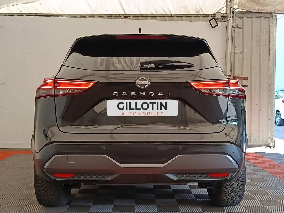 Vue arrière d’un Nissan Qashqai noir 2023 avec feux LED allumés et logo visible sur le hayon.
