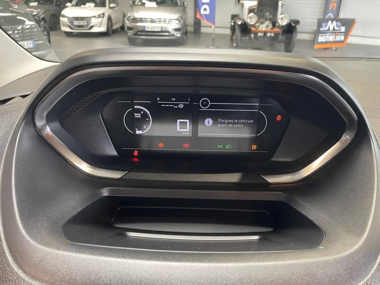 Vue rapprochée du tableau de bord numérique du Peugeot Partner 2026 affichant des alertes et informations de conduite.