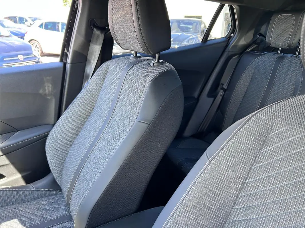 Vue intérieure des sièges avant et arrière gris du Peugeot 2008 Hybrid 136 e-DCS6 Allure, côté droit.