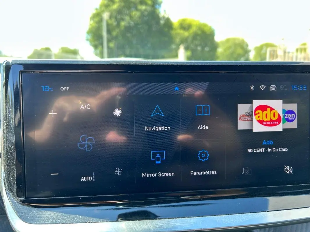 Écran tactile du tableau de bord du Peugeot 2008 Hybrid noir, affichant navigation et radio Ado.