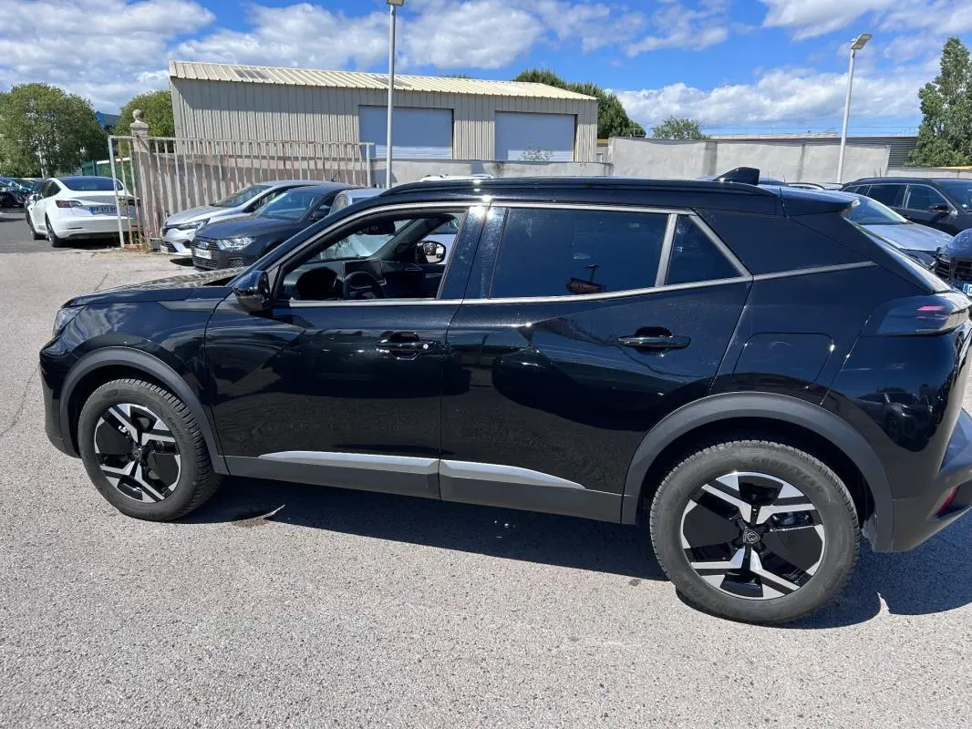 Peugeot 2008 Hybrid noir vue de profil côté gauche, avec barres de toit et jantes alliage 17 pouces.
