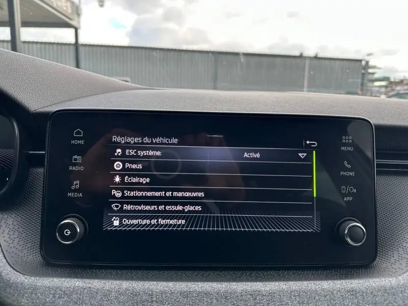 Écran tactile central du tableau de bord de la Skoda Scala blanc cristal affichant les réglages du véhicule.