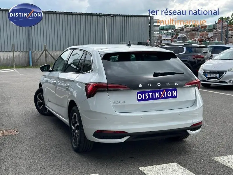 Vue 3/4 arrière droite d'une Skoda Scala blanc cristal avec feux arrière LED et jantes alu noires.