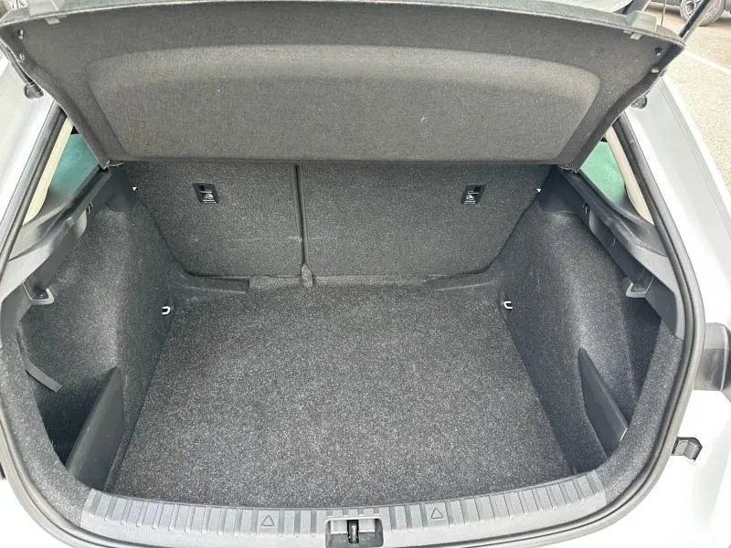 Vue intérieure du coffre spacieux et propre de la Skoda Scala blanc cristal, avec banquette arrière rabattable visible.