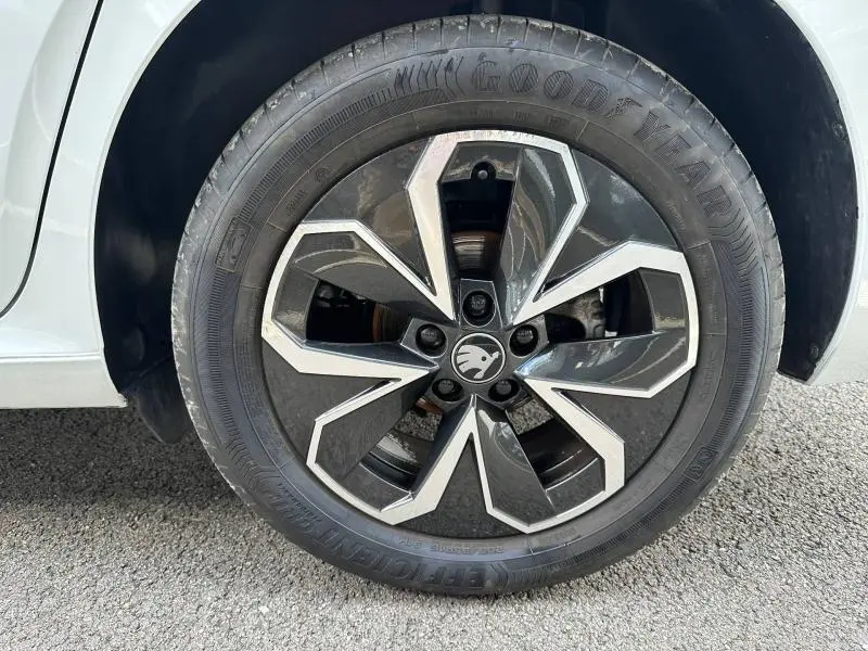 Gros plan sur la roue avant droite blanche d'une Skoda Scala 2025 avec jante alu au design noir et argenté.