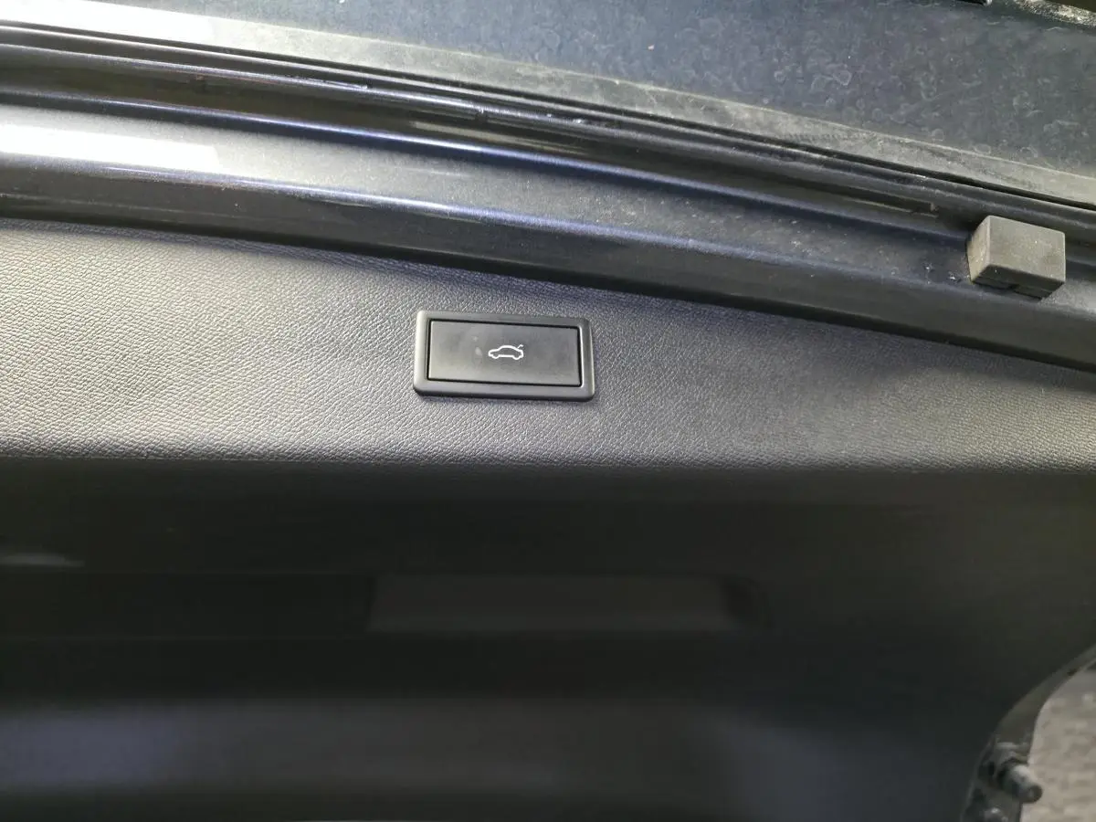 Bouton d'ouverture électrique du hayon sur la partie intérieure du coffre d'une CUPRA Leon Sportstourer gris.