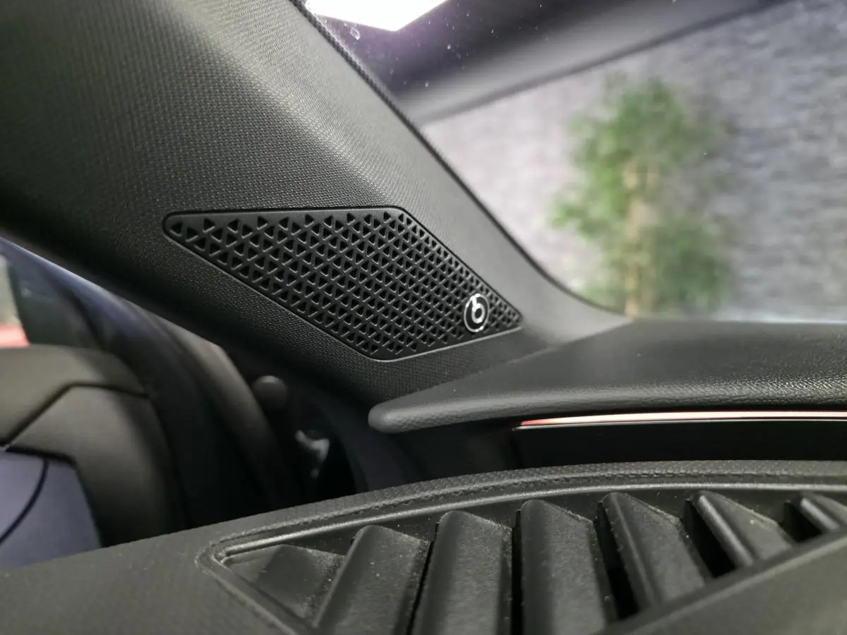 Gros plan sur l'enceinte Beats Audio intégrée au tableau de bord côté gauche d'un CUPRA Leon Sportstourer gris.