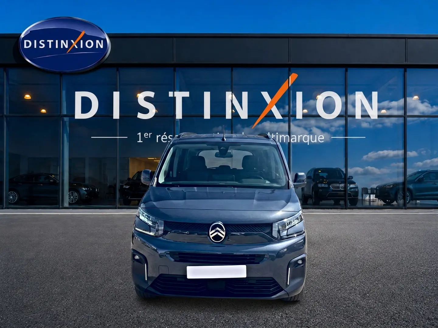 Vue frontale d'un Citroën Berlingo noir 2026 avec logo chromé et phares LED devant une vitrine Distinxion.