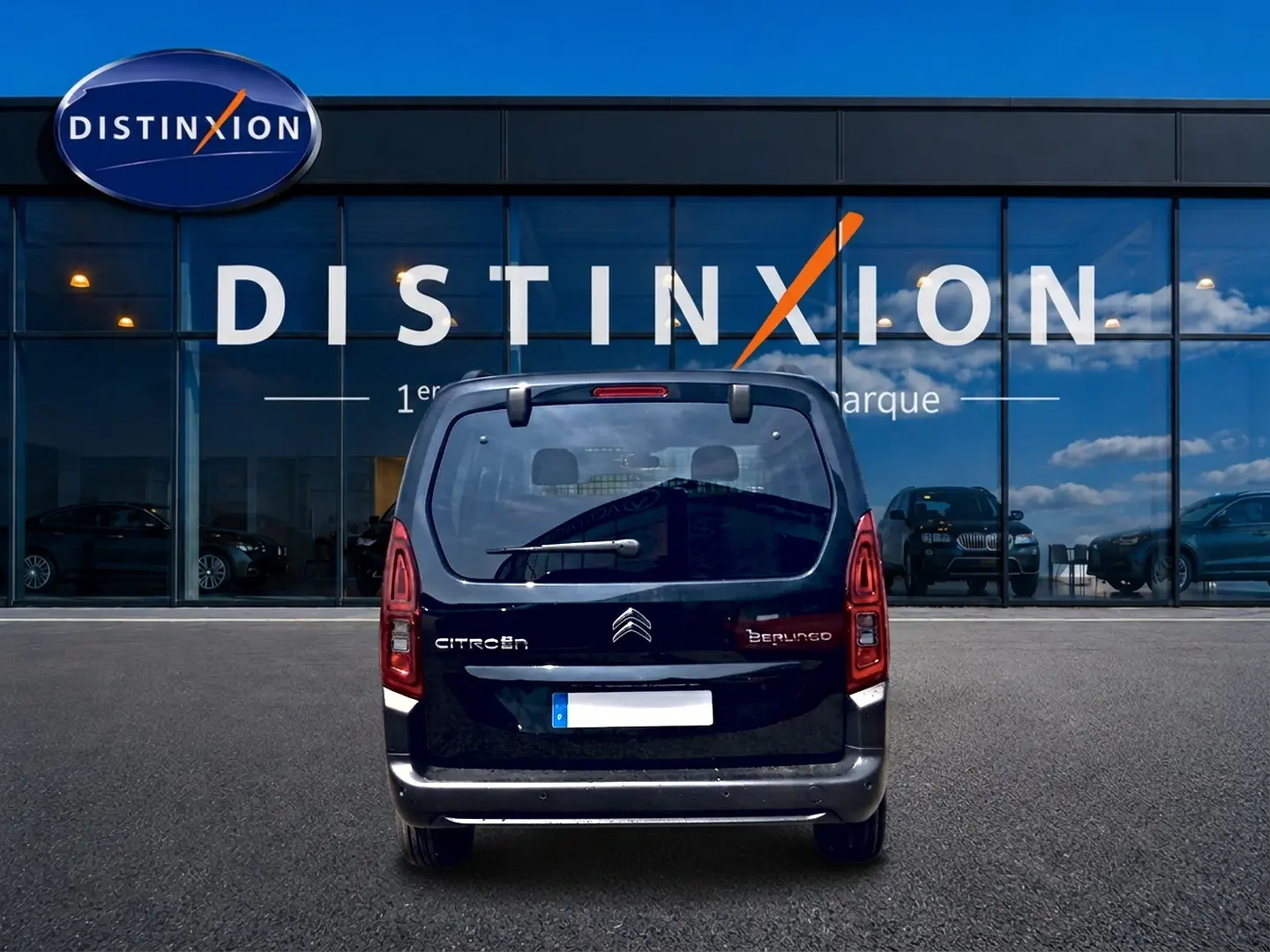 Vue arrière d’un Citroën Berlingo noir 2026 avec feux verticaux et hayon vitré devant un bâtiment vitré Distinxion.