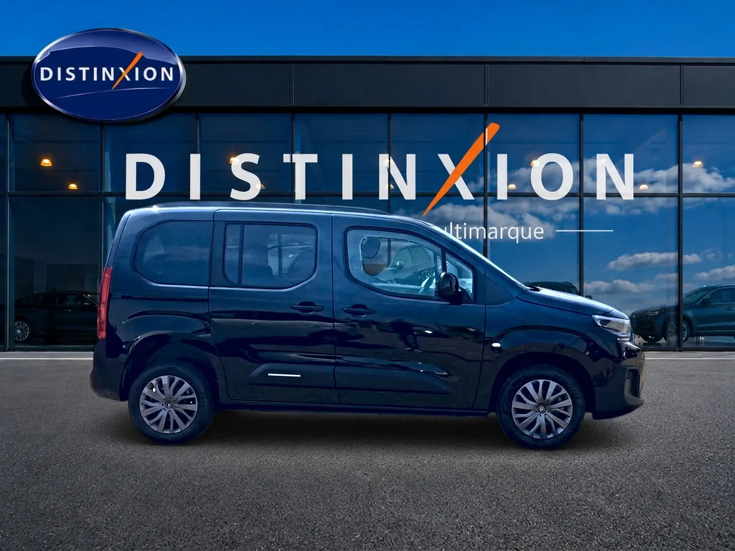 Profil côté gauche d'un Citroën Berlingo noir 2026 devant une vitrine avec logo Distinxion.