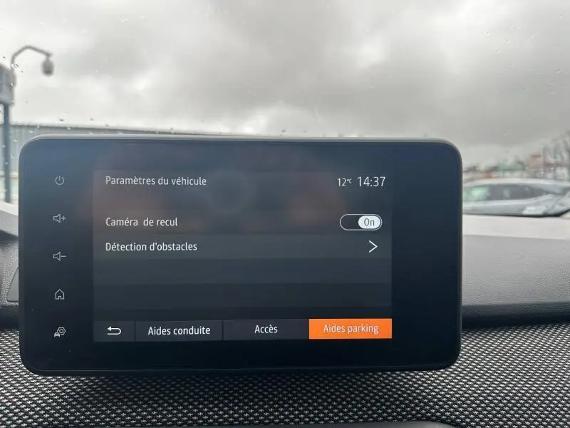 Écran tactile intérieur du Dacia Jogger affichant les paramètres d'aide au stationnement, vue frontale du tableau de bord.