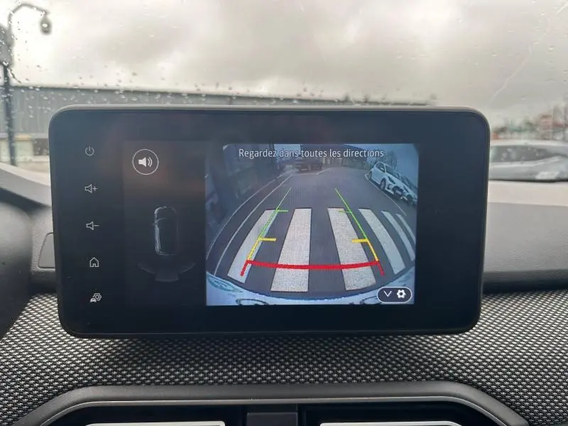 Écran intérieur montrant la caméra de recul du Dacia Jogger 2025, avec vue arrière sur un passage piéton et voitures stationnées.