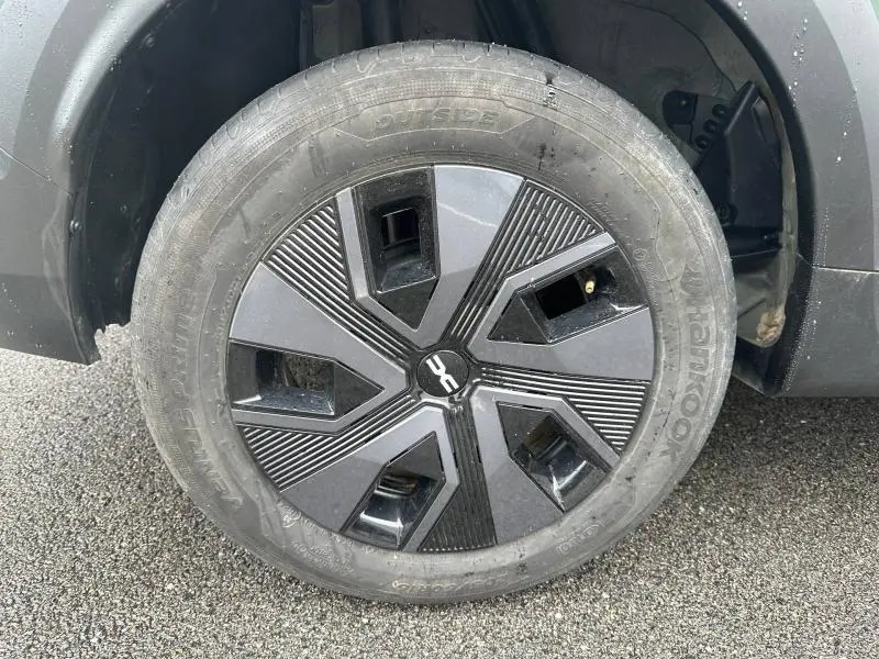 Gros plan sur la roue avant droite du Dacia Jogger 2025 en Kaki Lichen, avec jante noire au design géométrique.