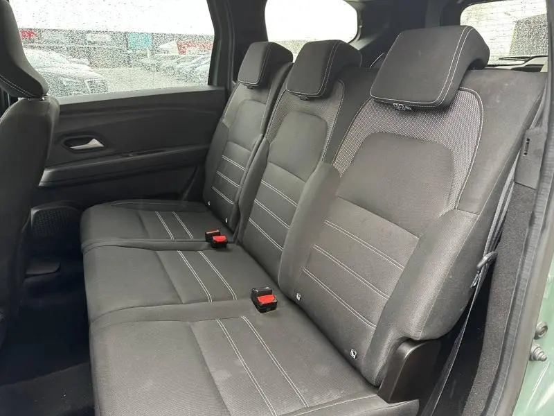 Vue latérale intérieure montrant la banquette arrière noire du Dacia Jogger 2025 en Kaki Lichen, version 7 places.