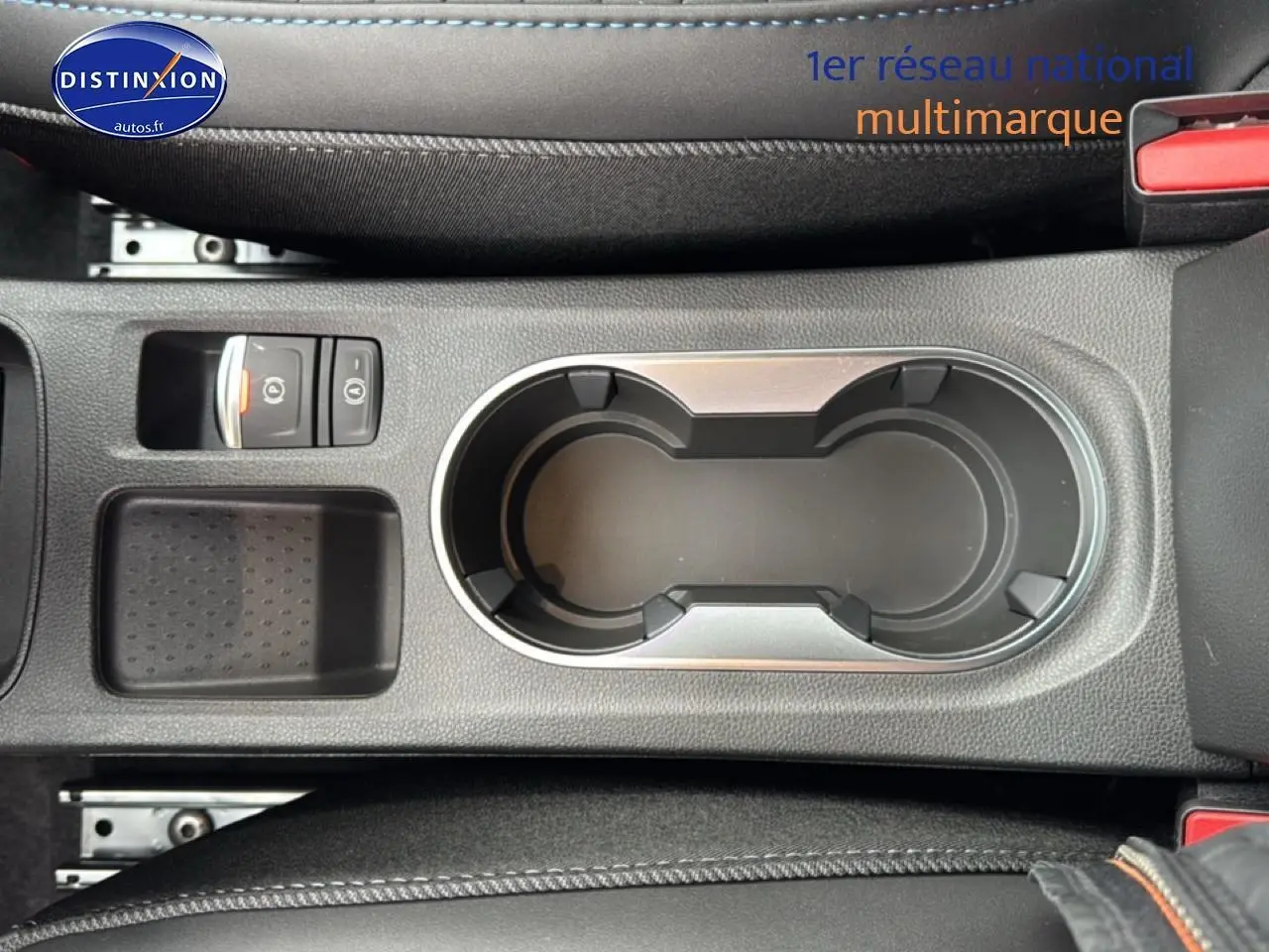 Vue plongeante sur la console centrale grise du Renault Captur 2025 avec porte-gobelets et frein à main électrique.