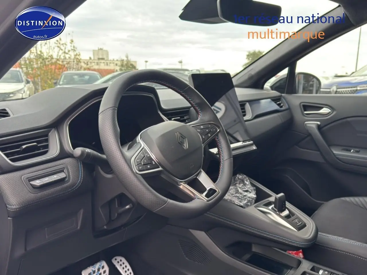 Vue intérieure côté conducteur du Renault Captur 2025, volant cuir multifonction et écran tactile vertical.