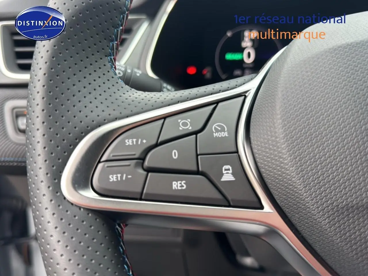 Gros plan sur les commandes multifonctions gauche du volant cuir perforé du Renault Captur gris rafale 2025 esprit alpine.