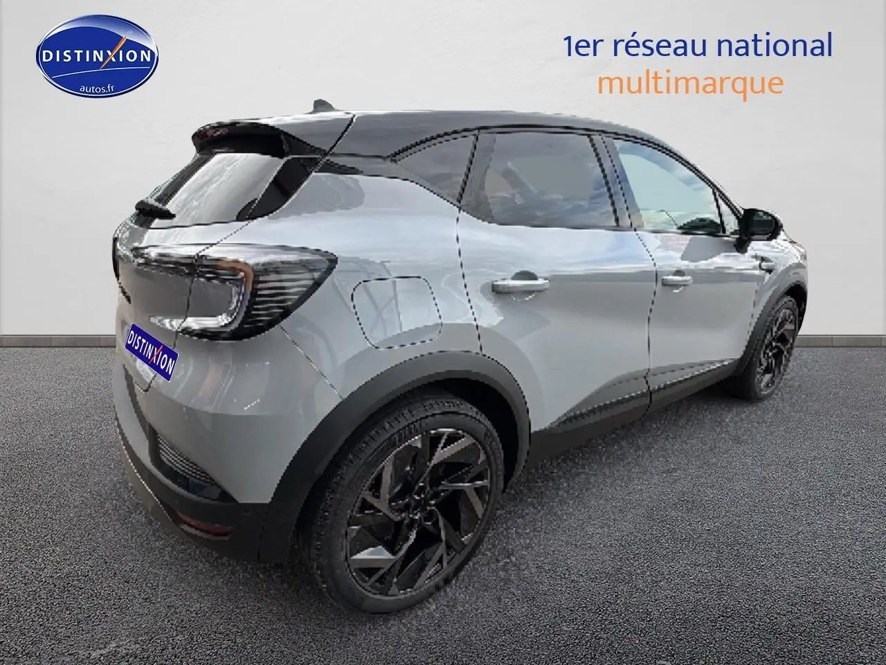 Renault Captur 2025 gris rafale et noir en vue 3/4 arrière droit, jantes noires et toit contrasté visible.