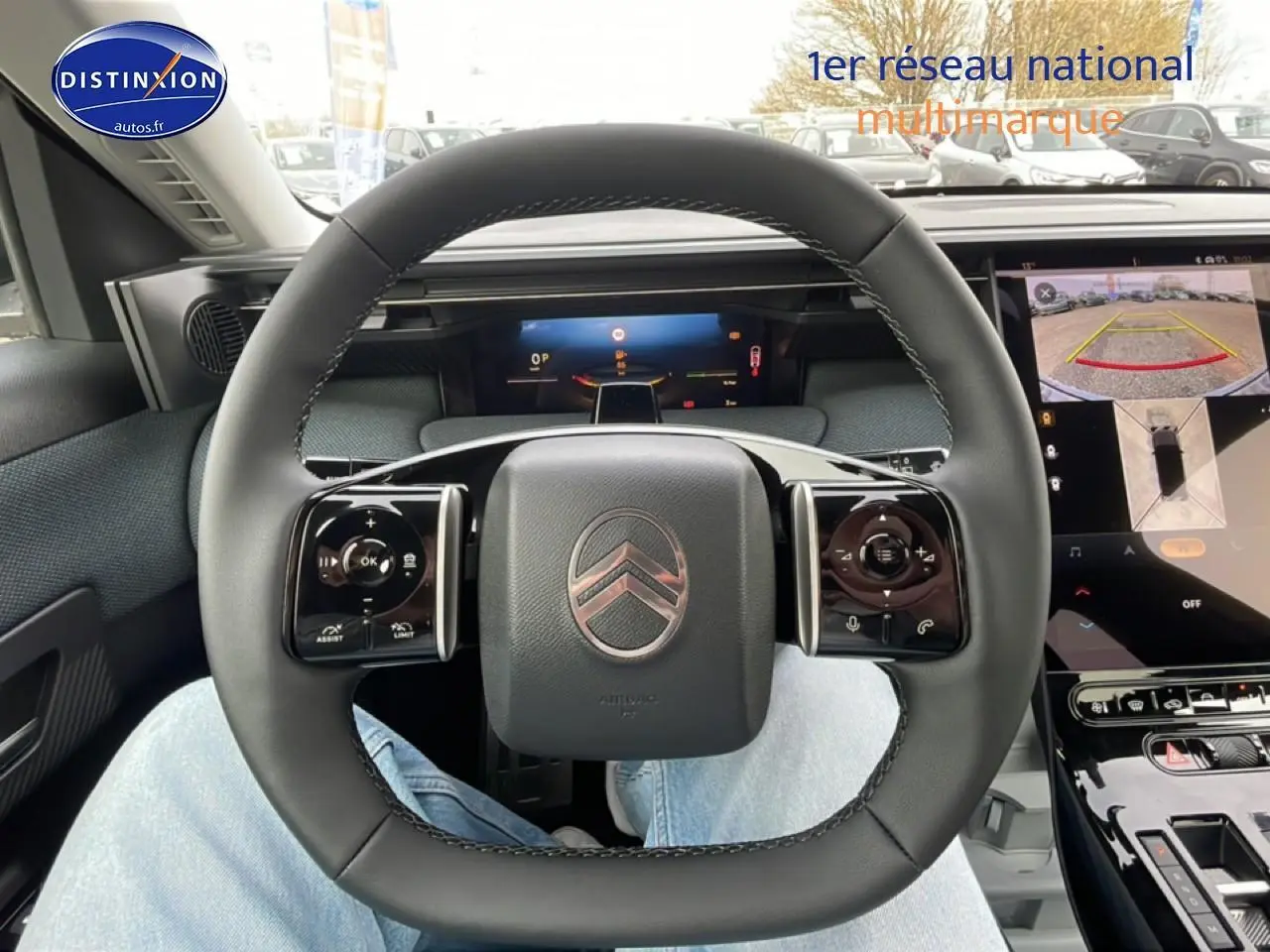 Vue intérieure centrée sur le volant noir du Citroën C5 Aircross 2026 avec écran tactile et caméra de recul affichée.