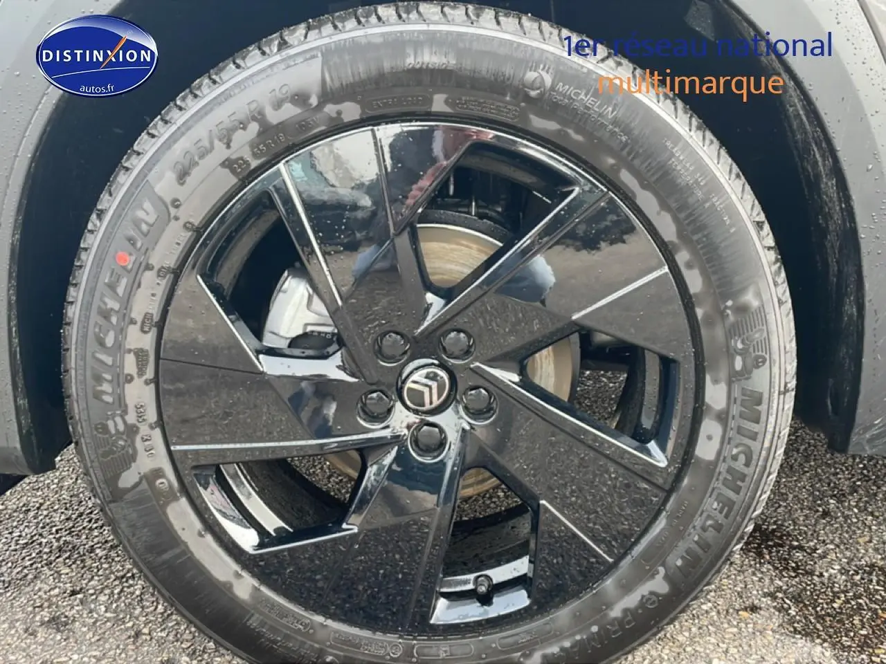 Gros plan sur la jante noire brillante 19 pouces Michelin du Citroën C5 Aircross gris, roue avant droite visible.