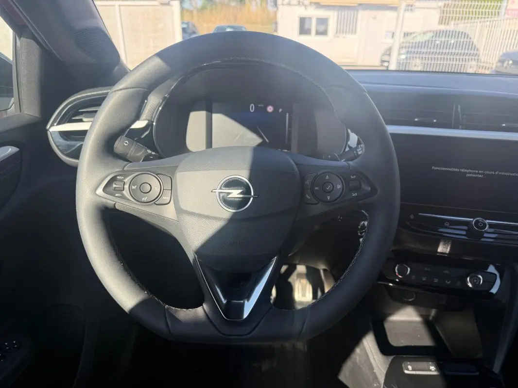 Vue intérieure centrée sur le volant noir de l'Opel Corsa 2025, avec tableau de bord et écran tactile visibles.