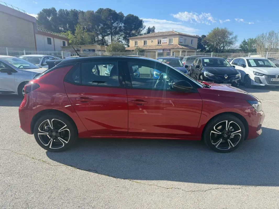 Opel Corsa rouge 2025 vue de profil côté gauche, avec jantes alliage noires et toit noir contrasté.