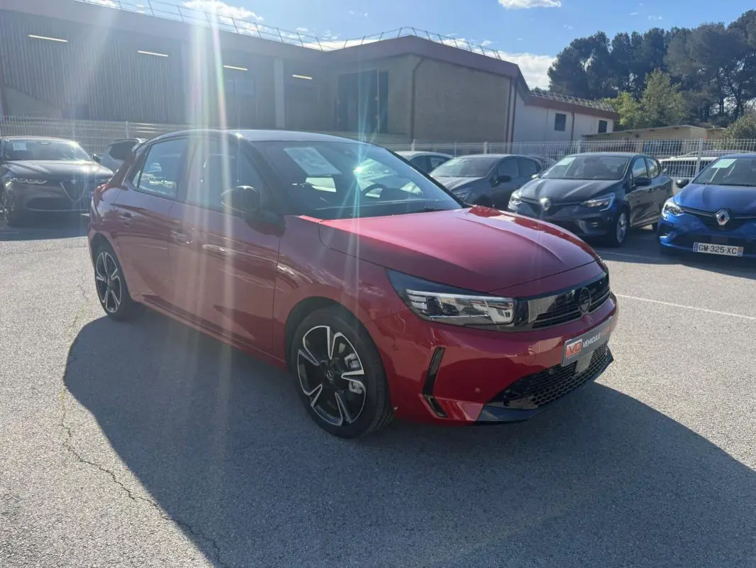 Opel Corsa 2025 rouge vue 3/4 avant droit, avec jantes noires et détails noirs sur la calandre et pare-chocs.
