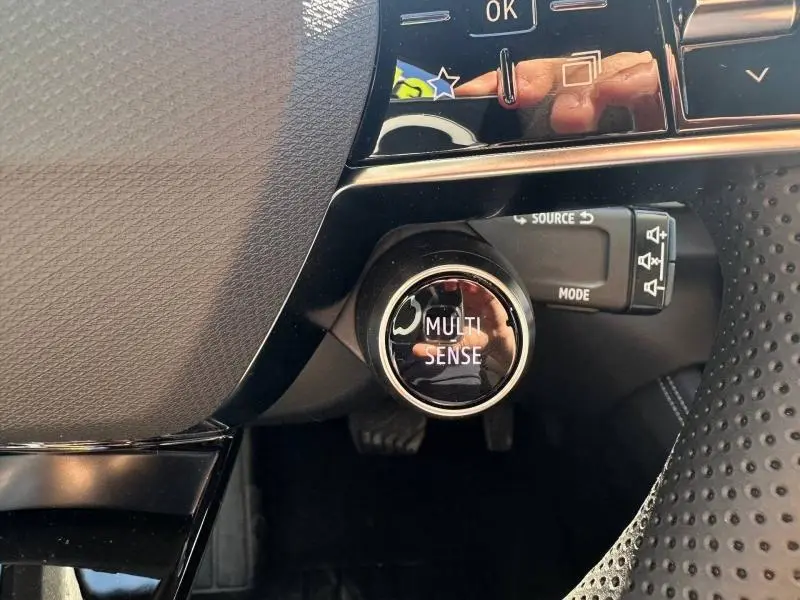 Gros plan sur le bouton Multi Sense côté gauche du volant perforé du Renault Austral gris Schiste 2025.
